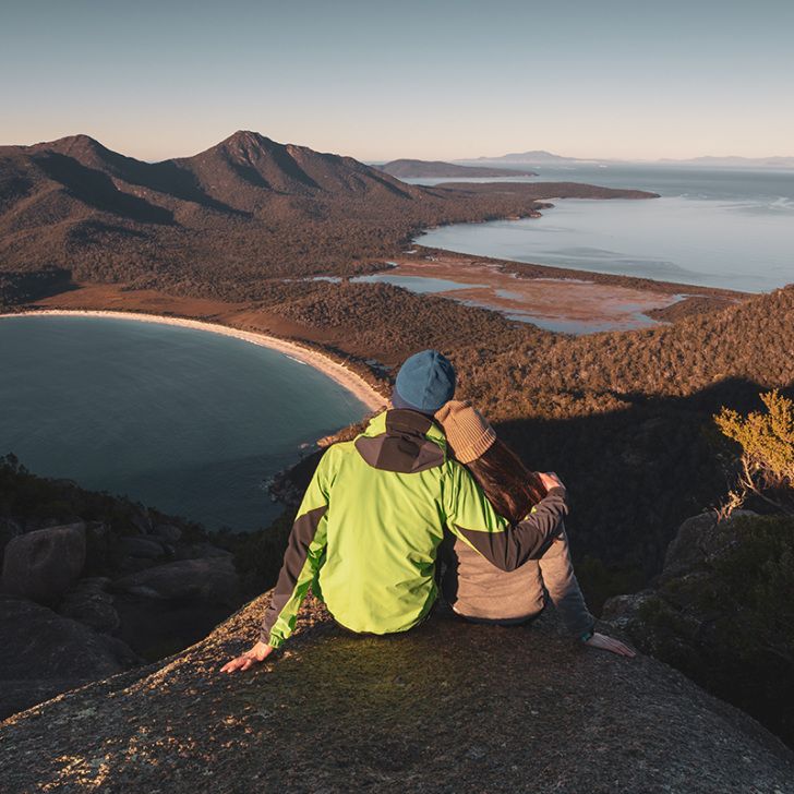 A couple watching sunrise at the peak of Mount Amos